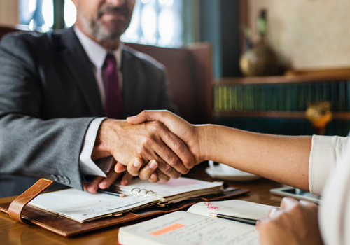 Two people shaking hands after a successful interview.