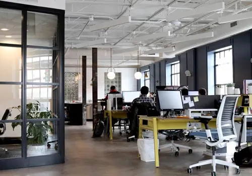 Large open office with multiple chairs, desks, and computers.